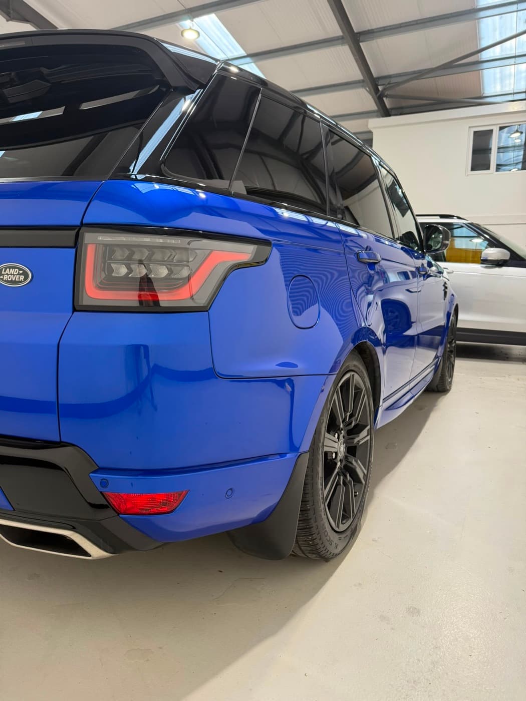 A blue Range Rover Sport detailed to a mirror finish